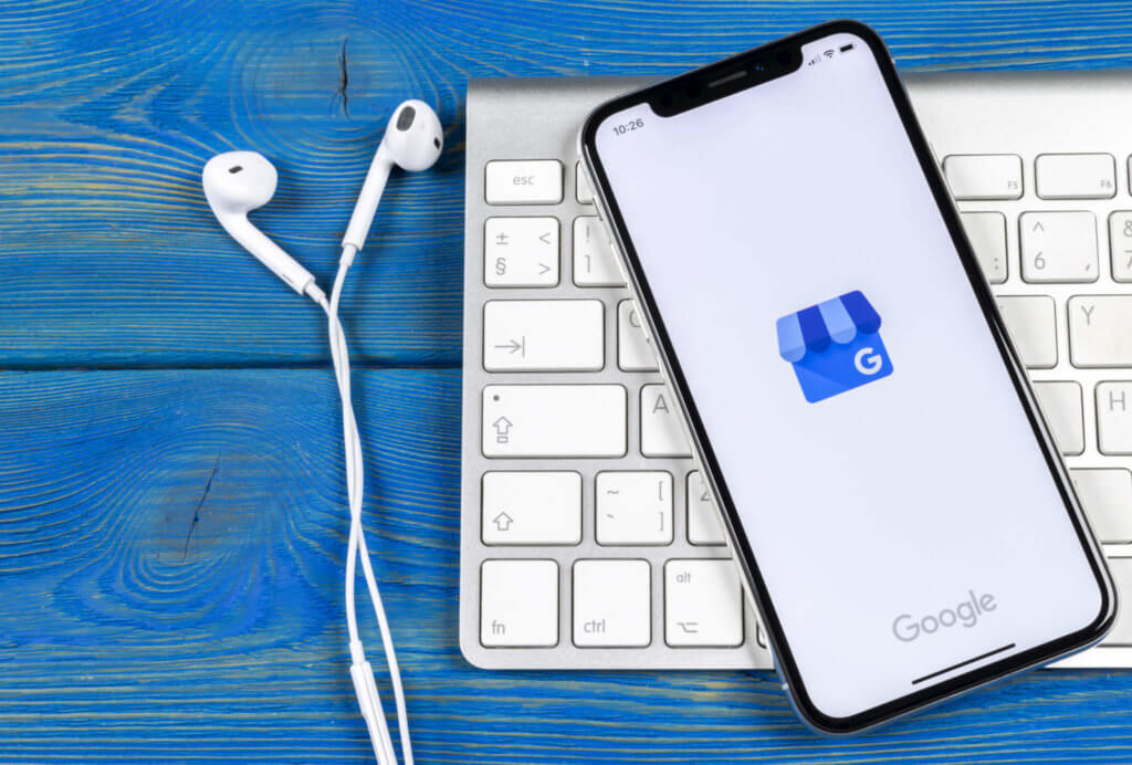 Google My Business on iPhone with headphones and keyboard