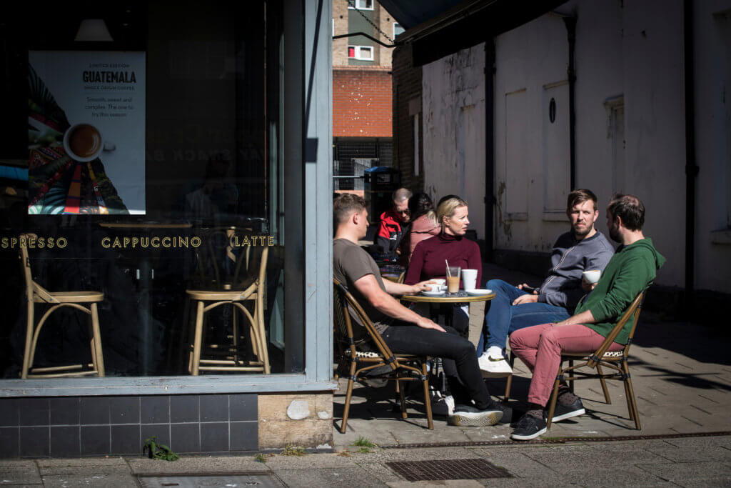 A group of four sitting talking outside a café